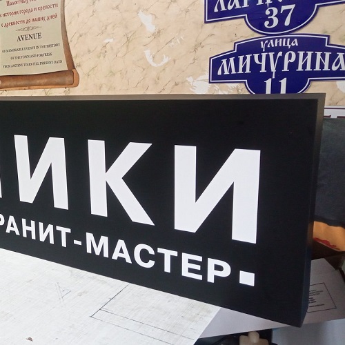 Белые буквы на черном световом коробе